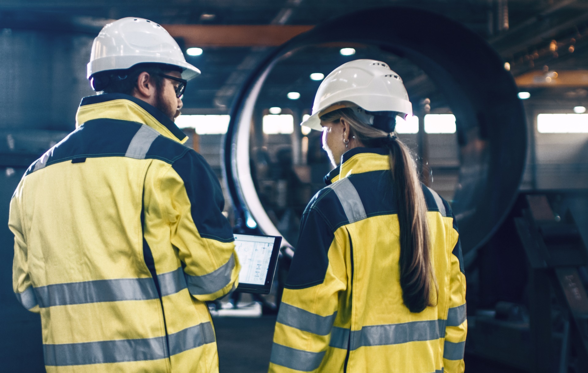 Two consultants in front of a turbine.